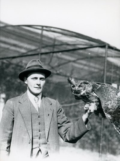 An Eagle Owl being held by J. Bailey, Overseer of Birds at London Zoo for thirty years. June 1920 by Frederick William Bond